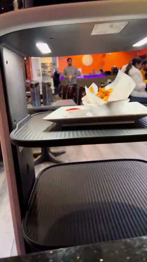 A2B's food-delivery robot carrying a plate from the kitchen to a booth